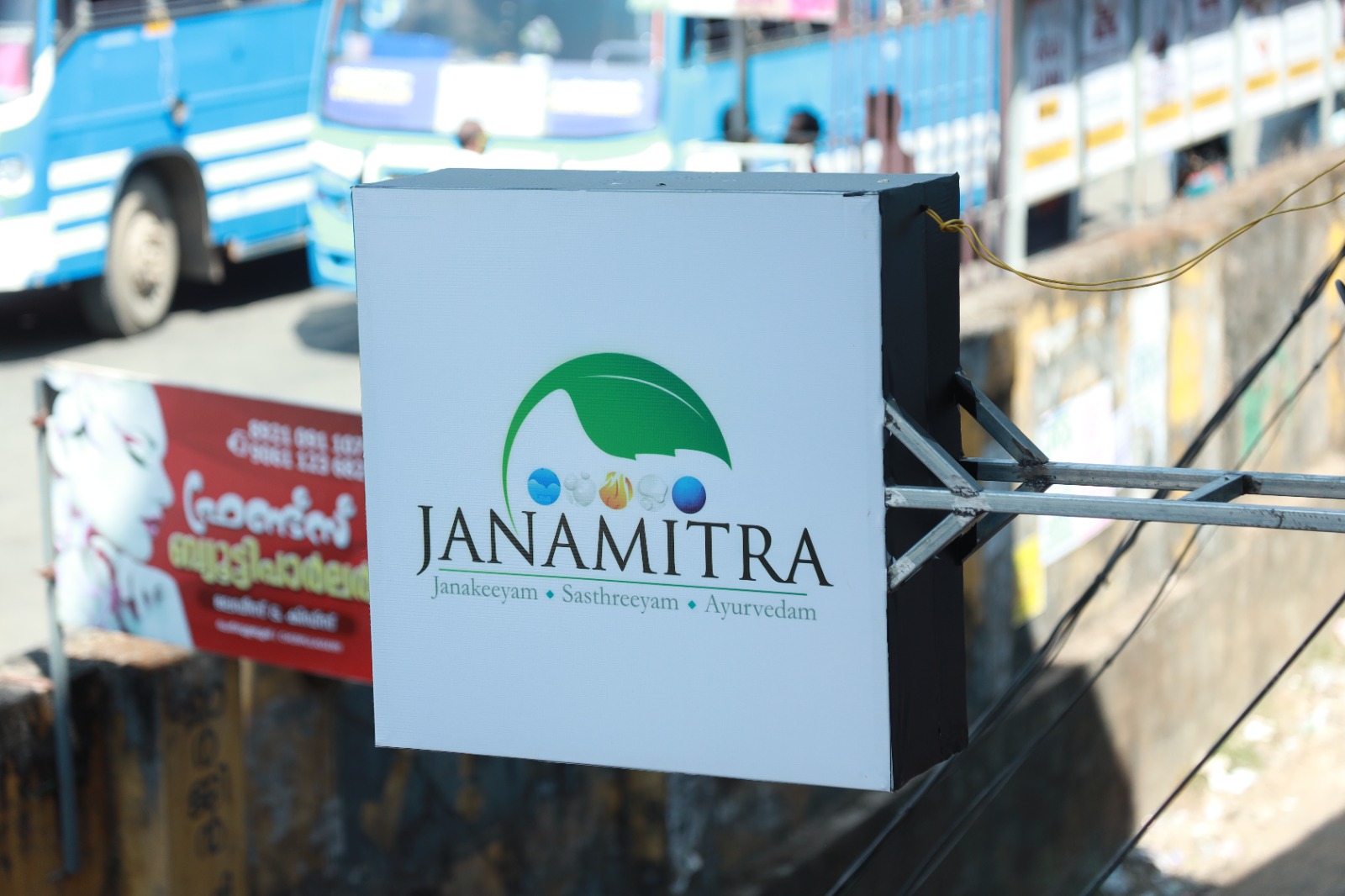 The Janamitra signboard on the street in Cherpulassery, carrying the motto Janakeeyam Sasthreeyam Ayurvedam